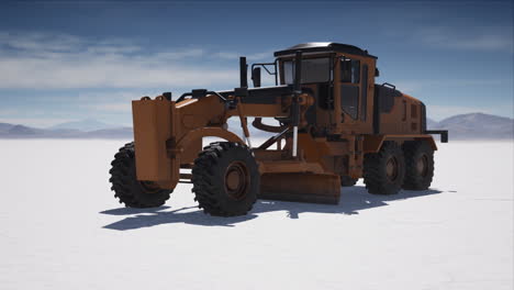 road grading machine on the salt desert road