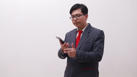 hombre de negocios asiático de pie mientras habla por teléfono