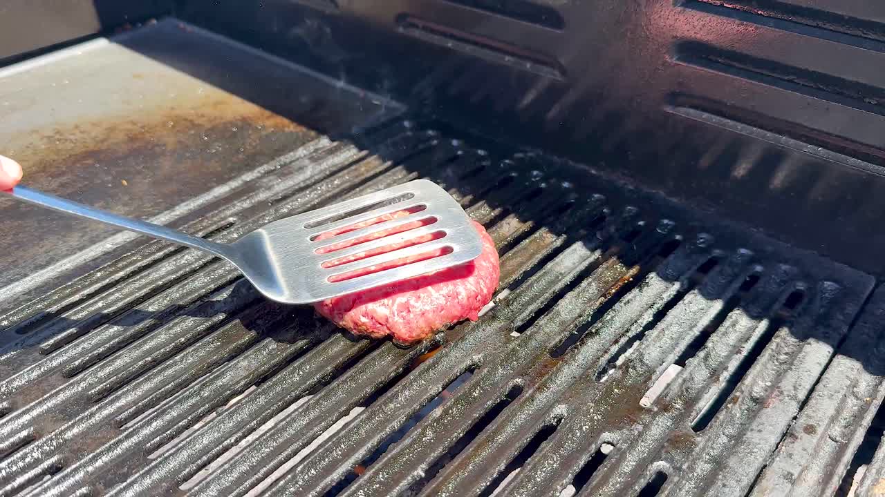 햄버거가 그릴에 을 때 불꽃이 불어납니다.