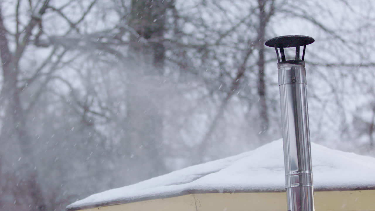 View of wooden sauna chimney and snowy roof in winter as hot steam escapes