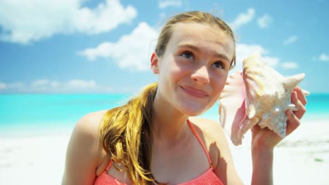 portrait of girl on beach holding conch shell