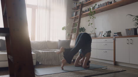 Mujer-De-Yoga-Saludable-Haciendo-Ejercicio-En-Casa-Practicando-Postura-De-Parada-De-Cabeza-Apoyada-En-La-Sala-De-Estar-Disfrutando-Del-Entrenamiento-Físico-Matutino