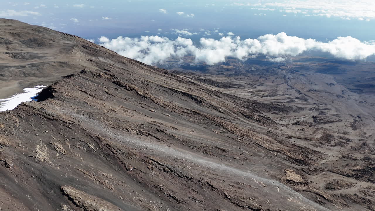 tomada de avión no tripulado del pico uhuru contra el telón de fondo del vasto paisaje del kilimanjaro. tomada aérea lenta y reveladora