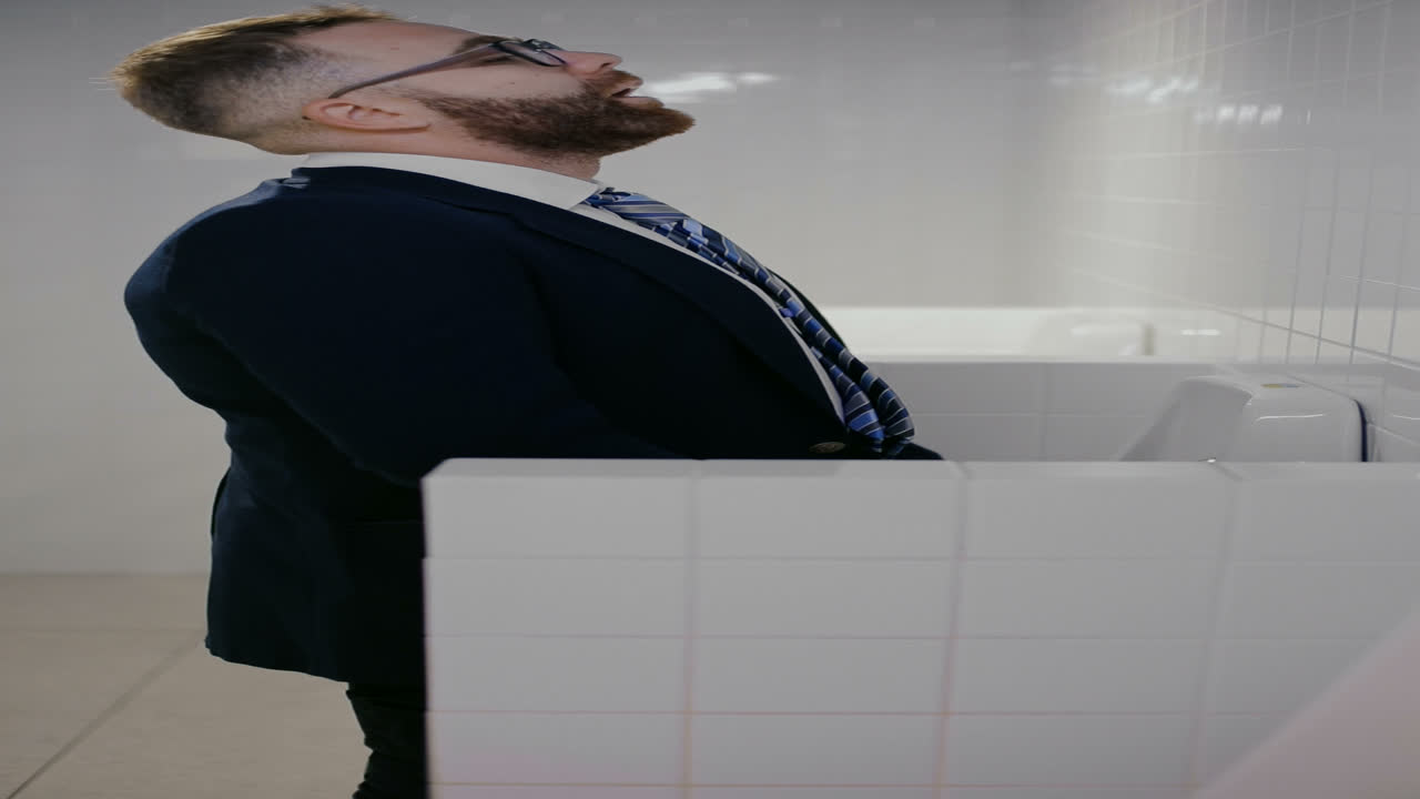 Uomo d'affari che usa l'orinatoio