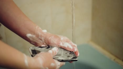 mujer lavándose las manos con jabón en el baño
