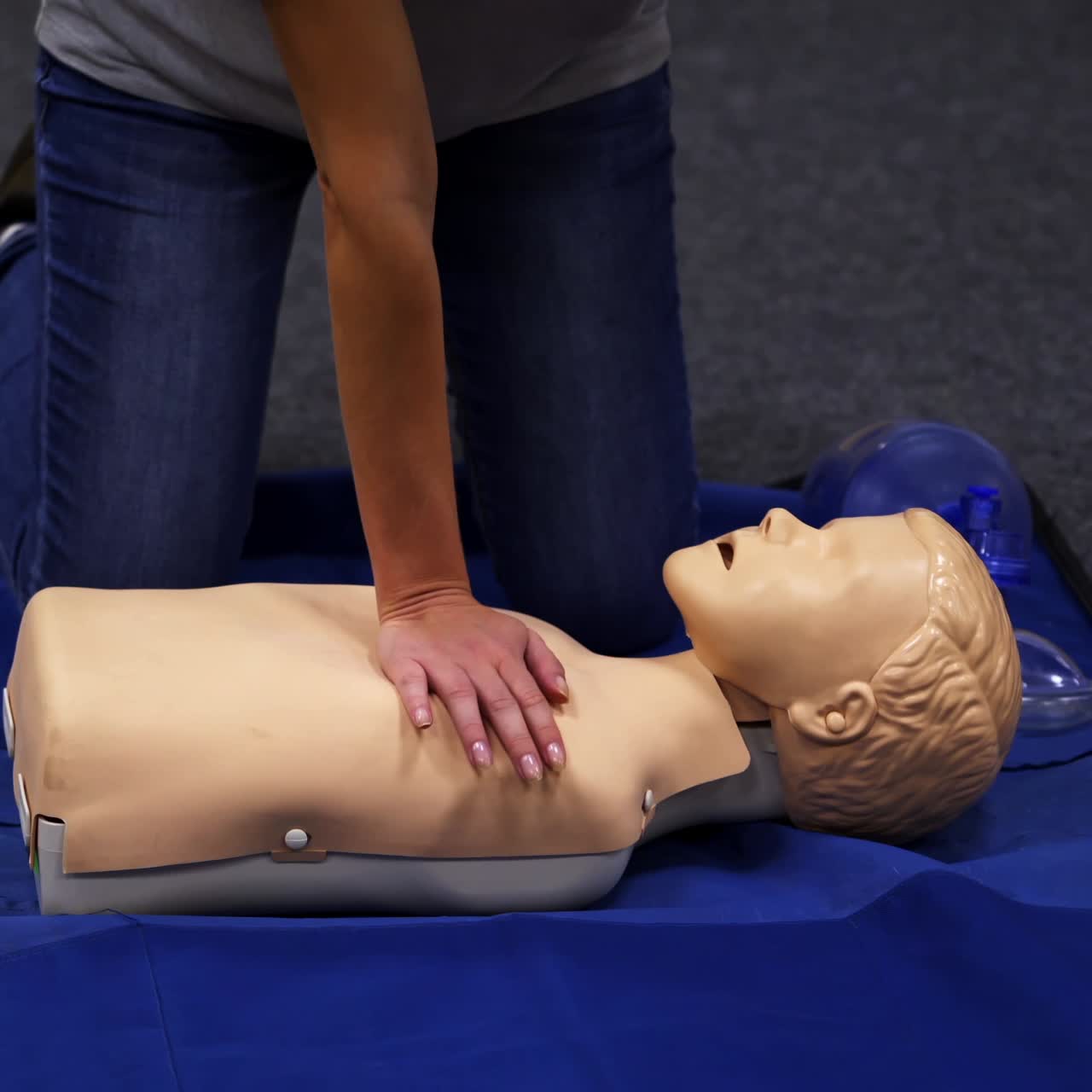 CPR training medical procedure. Demonstrating chest compressions on CPR doll in the class. Video from medical courses
