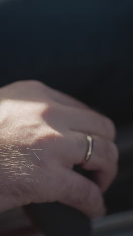 driver hand holds gear switch lever in contemporary auto closeup. man uses speed changing device while drives car. automobile control equipment
