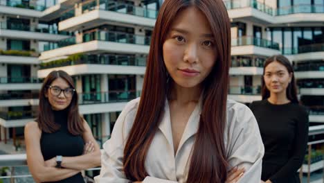 현대 도시 건축 배경에 대한 리더십과 팀워크를 나타내는 팔을 고 자신감 있게 서 있는 전문 사업가 여성