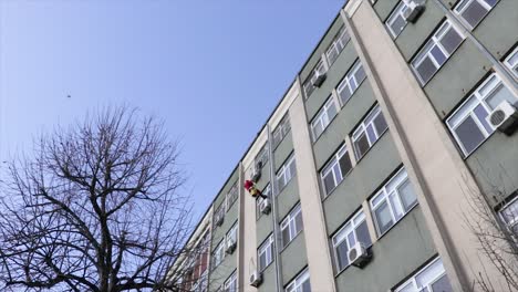 santa claus climbing down on the exterior wall of a hospital