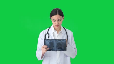 Tensed-Indian-female-doctor-checking-X-ray-Green-screen