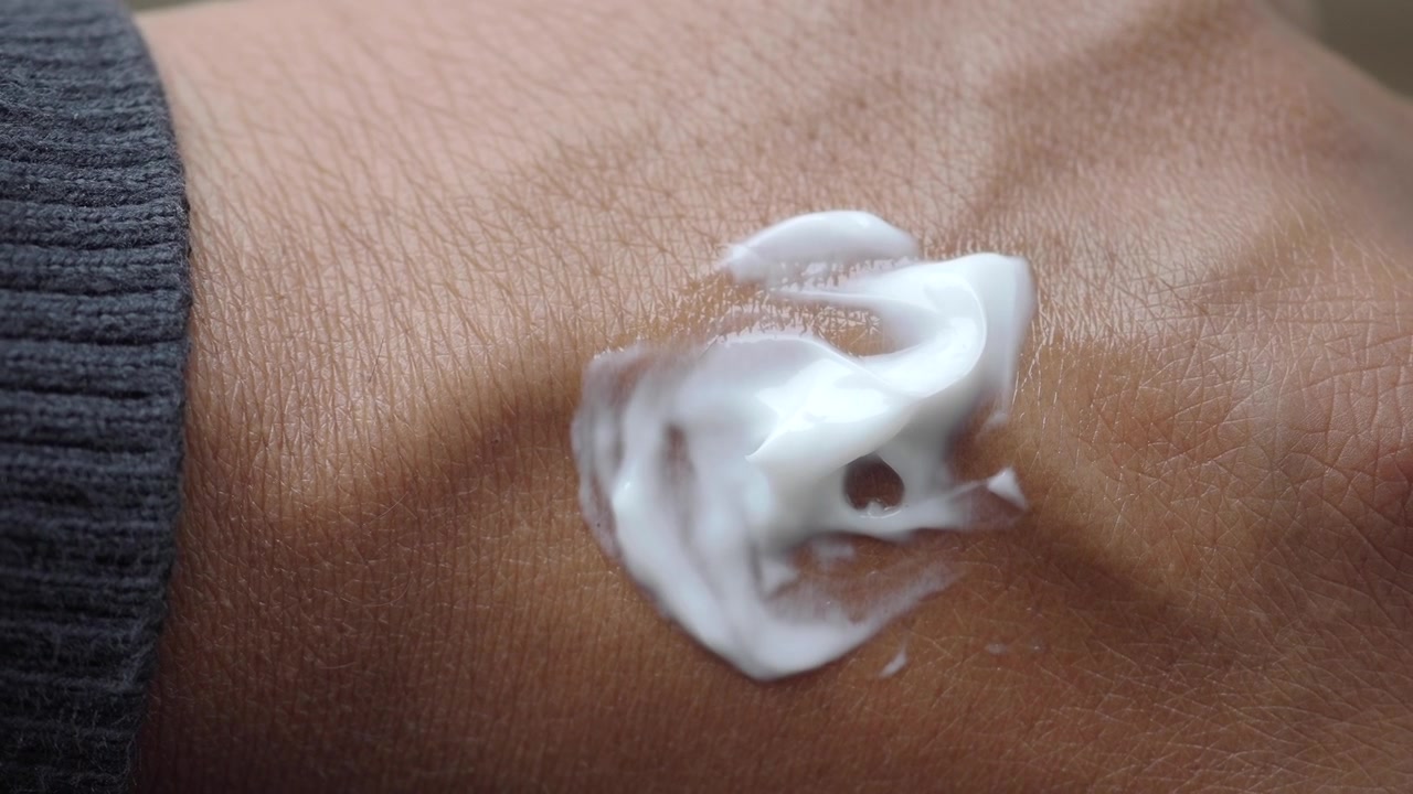 Primer plano de crema blanca en una mano humana