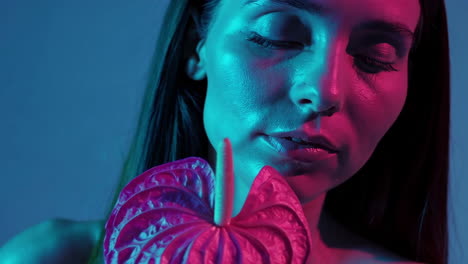 vibrant portrait of a woman with an anthurium flower in neon light