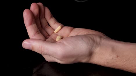 drug addict pouring prescription medicated pills into shaky hands