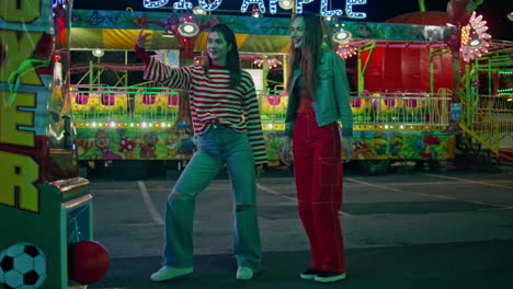 teenage girls having fun at amusement luna park. joyful happy female hit ball