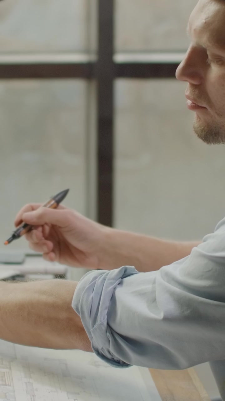 Architect Working on Blueprints at Drafting Table