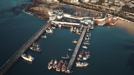 aerial drone view captures boats moored along pier at harbor during daytime in iceland, creating picturesque scene of marina, with boats neatly lined up