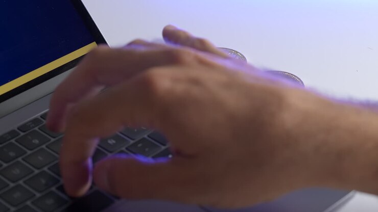 A mans hand typing on a keyboard with