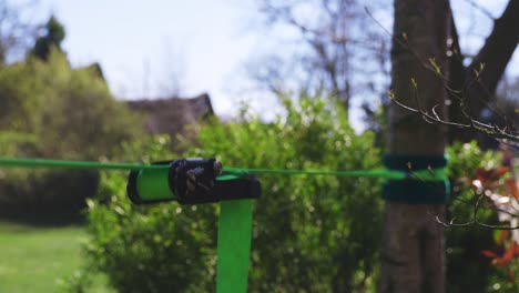 nahaufnahme der slackline-ratsche, während die person versucht, darauf zu stehen, was einige große wackeln und kleine zittern verursacht