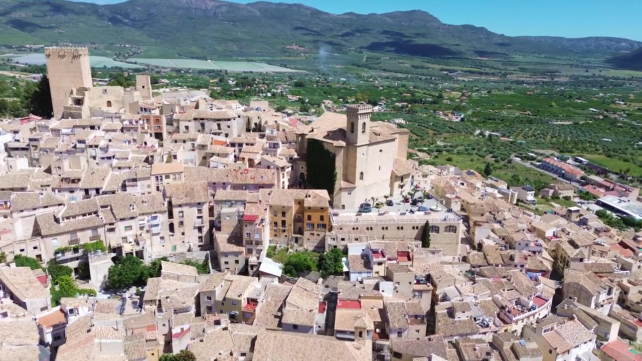 Vista aerea con drone della storica città di Calasparra nel sud della Spagna, con case del centro storico, castello medievale, paesaggio montano, architettura tradizionale, destinazione di viaggio e un panoramico panorama urbano.
