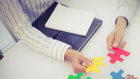 animation of two business people holding colourful puzzle pieces