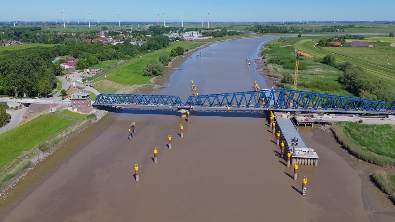 Drone footage of the Friesenbrücke, Europe’s largest railway lift bridge under construction. Spanning the River Ems near Leer and Papenburg, shown in closed position on a sunny day.