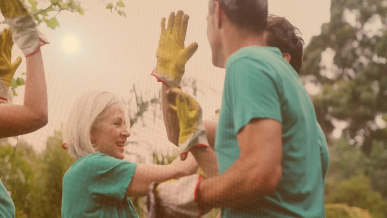 video de luces sobre un grupo feliz y diverso recogiendo basura dando cinco en el campo