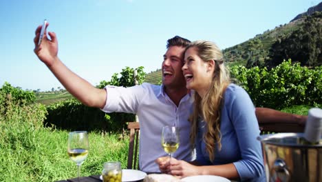 pareja feliz tomando una selfie con el teléfono móvil mientras beben vino 4k