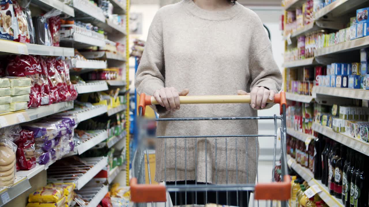 젊은 여성이 식료품 가게에서 고 쇼핑을 하고 있다