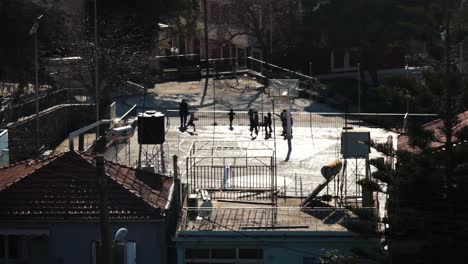 street basketball court with the silhouettes of children playing in slow motion