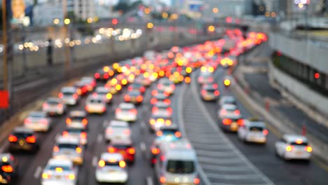 Dense-rush-hour-car-traffic-in-the-evening-with-red-back-lights,-blurred-highway-view