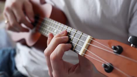 person playing ukulele at home. - closeup shot