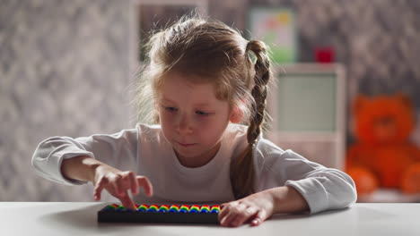 schoolgirl with blonde braids learns to do sums with abacus