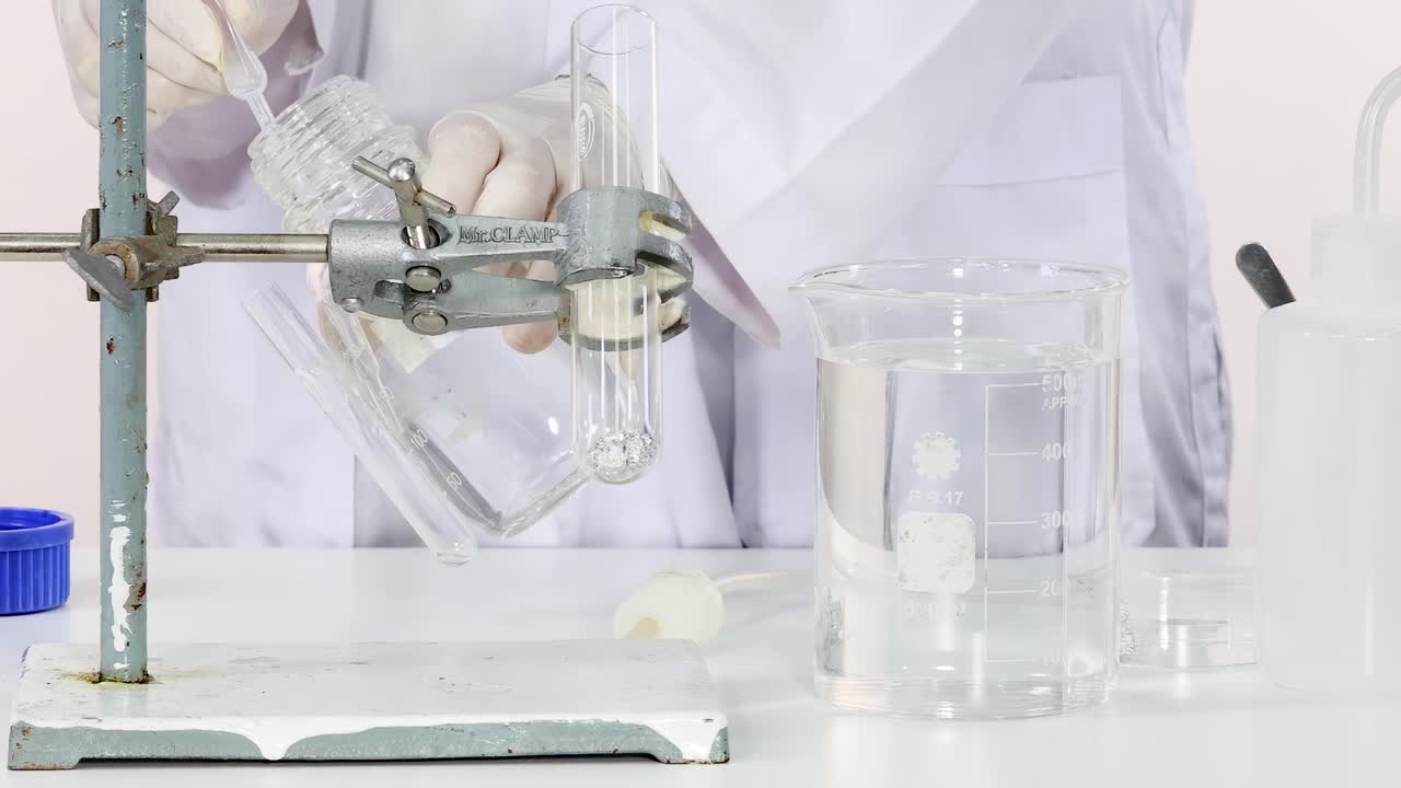 Scientist carefully transfers liquid into a test tube using a clamp setup in the laboratory.