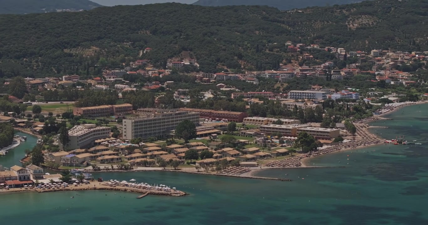 Ilha de Corfu, Grécia, sobrevoo aéreo v7 com teleobjetiva em vista aérea revelando Moraitika, Mesongi, praias de resort, mar turquesa e colinas arborizadas - Filmado com Mavic 3 Pro Cine - 16 de julho de 2024