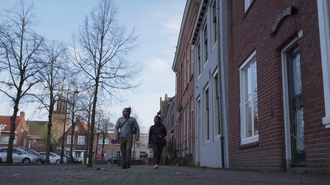 Tourist couple visiting old small Dutch village, low angle view, sunny day