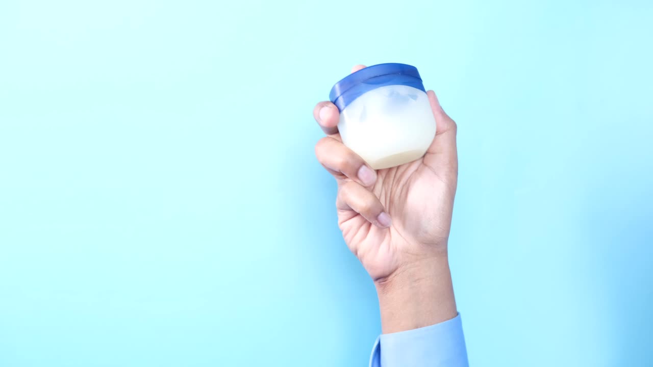 mano con un frasco de crema