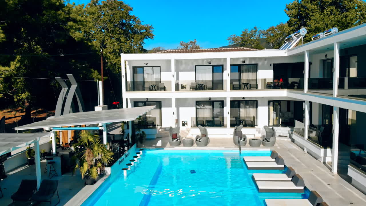 ASPROVALTA, GREECE - SEPTEMBER 25, 2020: Avaton Beach Luxury Resort from the drone. Pool with blue water, sunbeds, main building with multiple hotel rooms and terraces, greenery around it