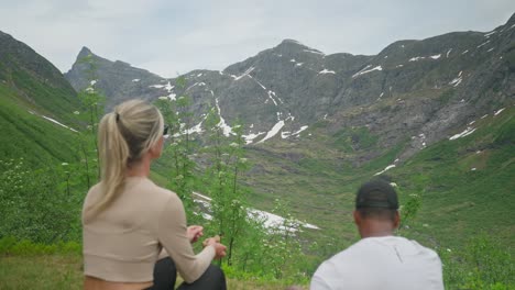 pareja disfrutando de la vista panorámica de las montañas durante una caminata en noruega