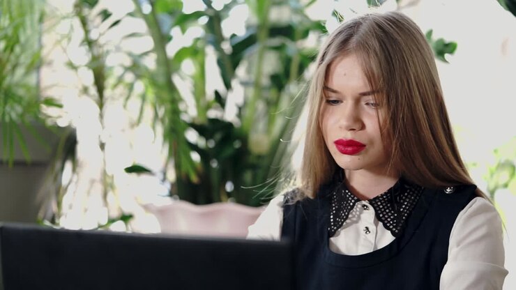 Giovane donna che lavora su un computer portatile in un caffè