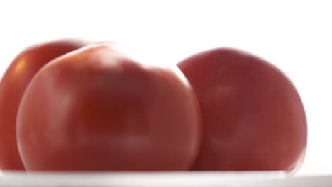 fresh red tomatoes rotating on white background close-up.