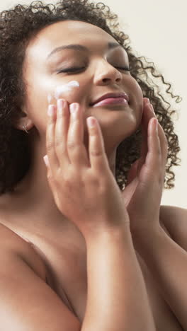 vertical video: applying moisturizer, plus size woman embracing self-care and body positivity