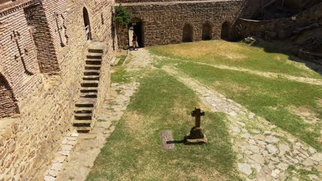 woman walking across courtyard at david gareji monastery in georgia