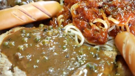 Close-Up-Footage-of-Combo-Steak-Included-Beef,-Fried-Fish-and-Sausages-Topped-With-Fresh-Pepper-Gravy-and-Spaghetti-Red-Sauce