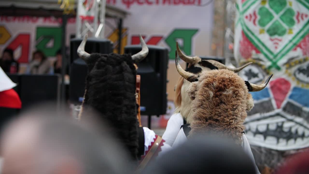 슬로우 모션으로 함께 춤을 추는 뿔이 있는 여러 가면 머리