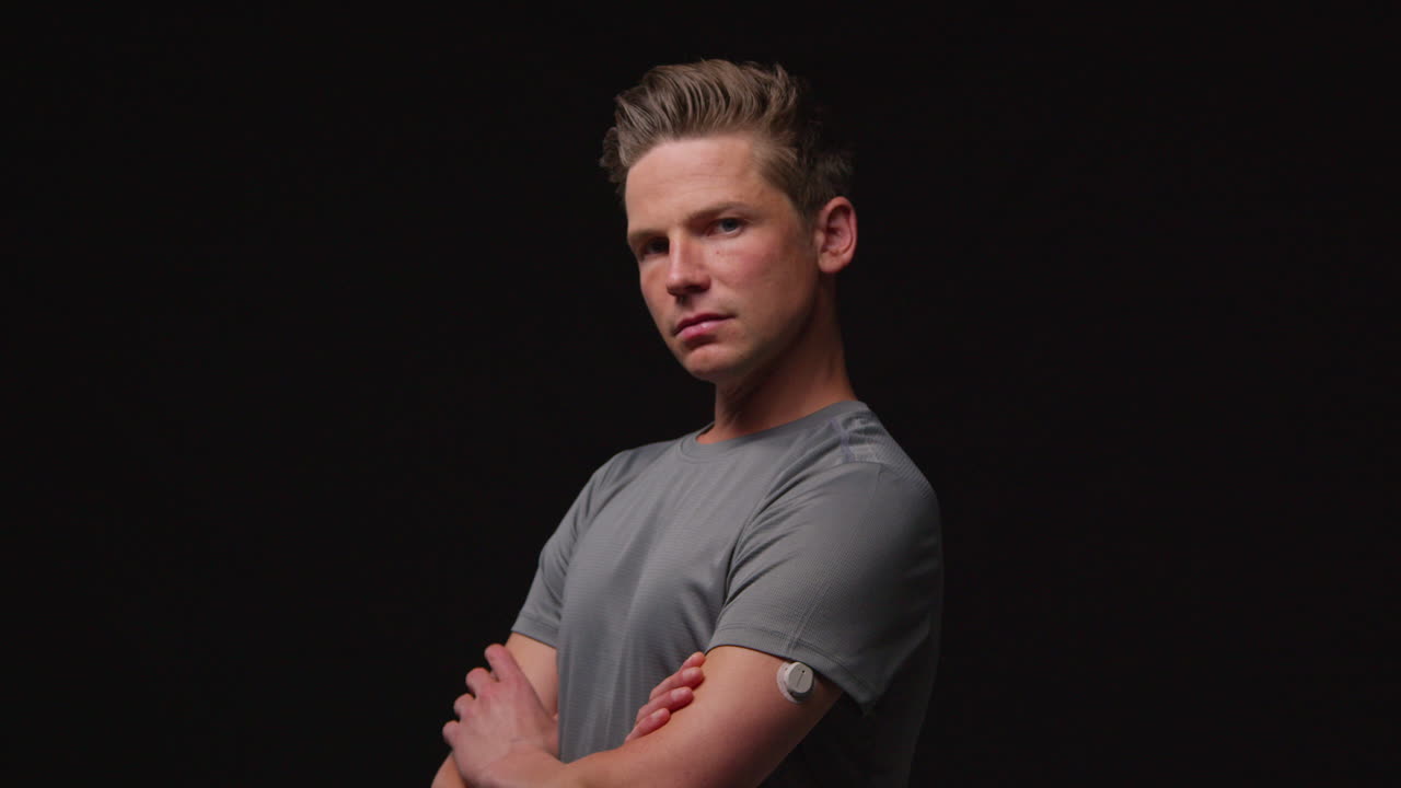 검은색 스튜디오 배경에 대한 스포츠 이벤트를 위해 심리적으로 준비하고 체육 의상을 입은 심각한 남성 운동 선수의 초상화.