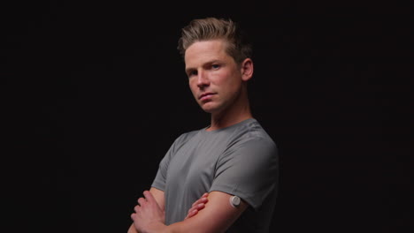 Portrait-Of-Serious-Male-Athlete-Wearing-Fitness-Clothing-Training-Warming-Up-And-Preparing-Psychologically-For-Sports-Event-Against-Black-Studio-Background-5