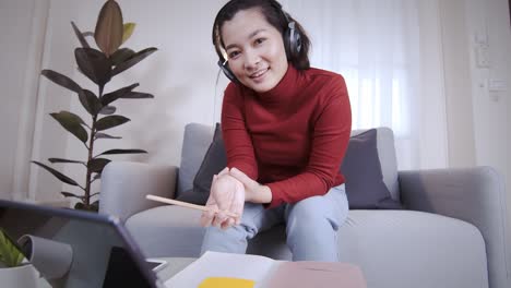 freelance woman redshirt using tablet with headphone for meeting online at home