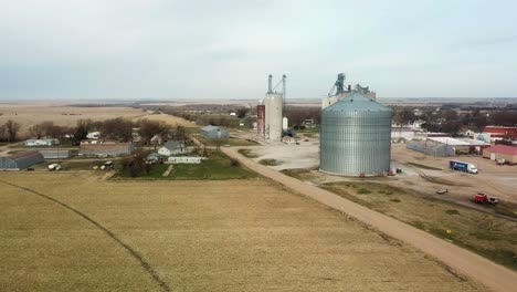 aerial drone view of small town in rural nebraska with agribusiness to support grain storage and sale - bladen, nebraska, usa
