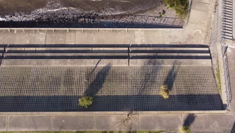 Overhead-Shot-Of-Man-Walking-On-Geometric-Shapes-On-Ground-At-Buenos-Aires-Waterfront