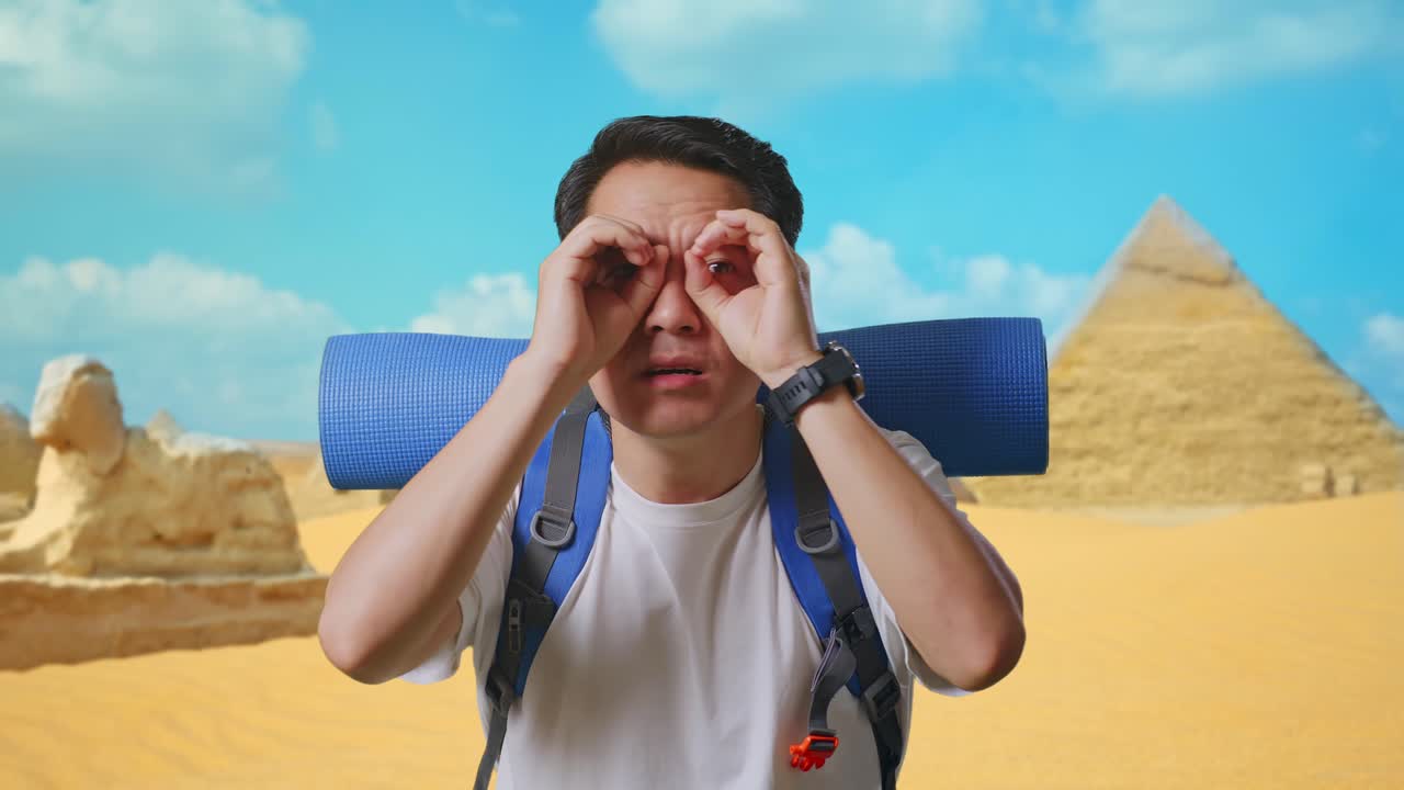 Close Up Of Asian Male Hiker With Mountaineering Backpack Making Binoculars Gesture Looking At Something Then Saying Wow While Traveling In Pyramid Of Giza